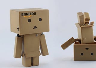 Amazon box figures symbolizing seller concerns over mandatory prepaid return label policy changes.